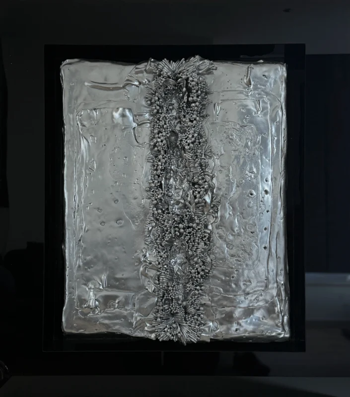 Zhu Qing, Reconstruction No.50, mixed media relief, silver surface with axial compression and granular accumulation forming a central spine-like structure