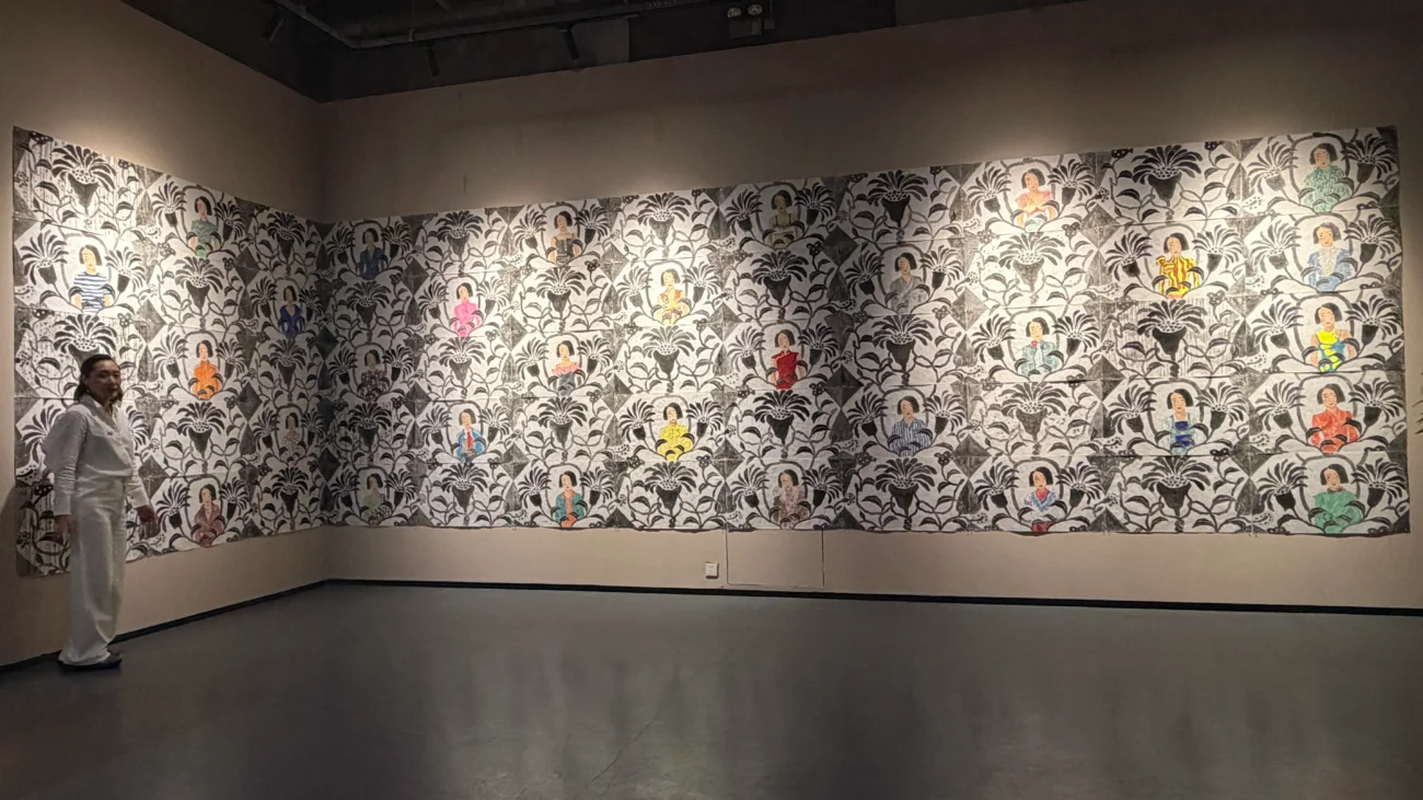 A large-scale mixed-media installation composed of sixty interconnected images featuring botanical patterns, portraits, and symbolic motifs arranged in a grid structure.
