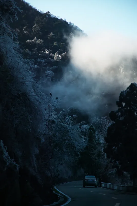 Clouds and mountain slopes merging in mist above a winding road in Wang Wulong’s Dreaming of Mount Lu series.