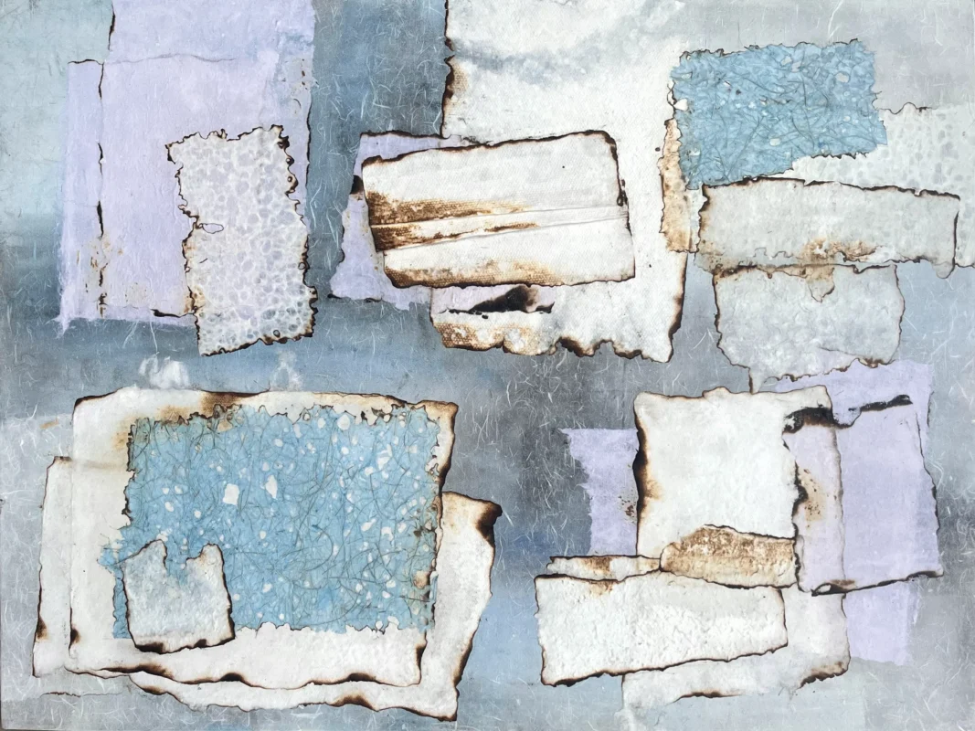 Floating paper elements arranged across a pale blue mixed-media surface.