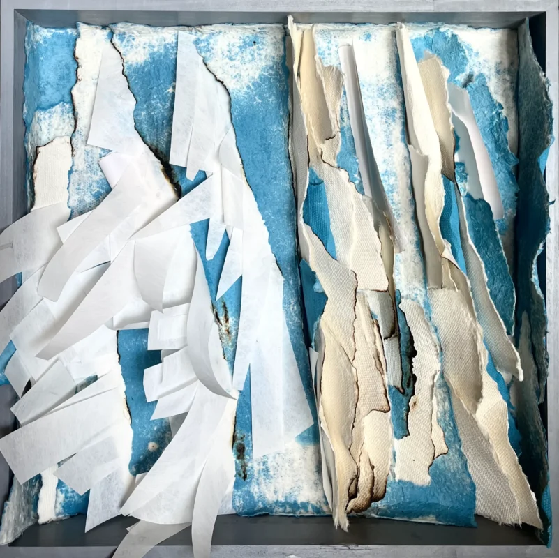Vertical paper assemblage emerging from a vivid blue background.