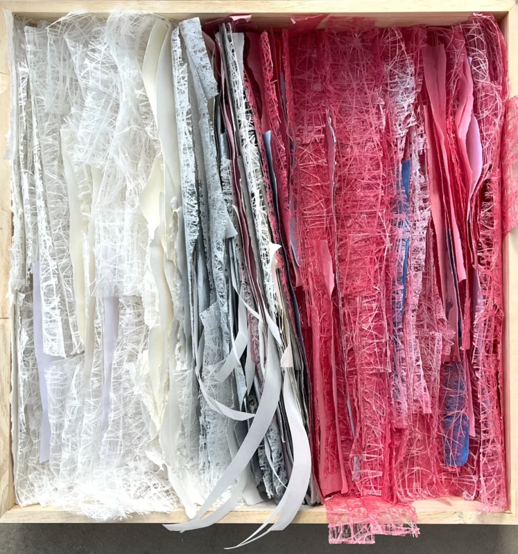 Textile and mixed-media composition divided into white and crimson sections.
