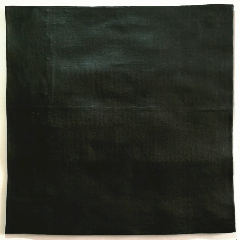 Repeatedly layered and wrapped black xuan paper forms a dense textured surface, where handwritten black characters merge into the material itself, creating a restrained yet powerful visual tension.