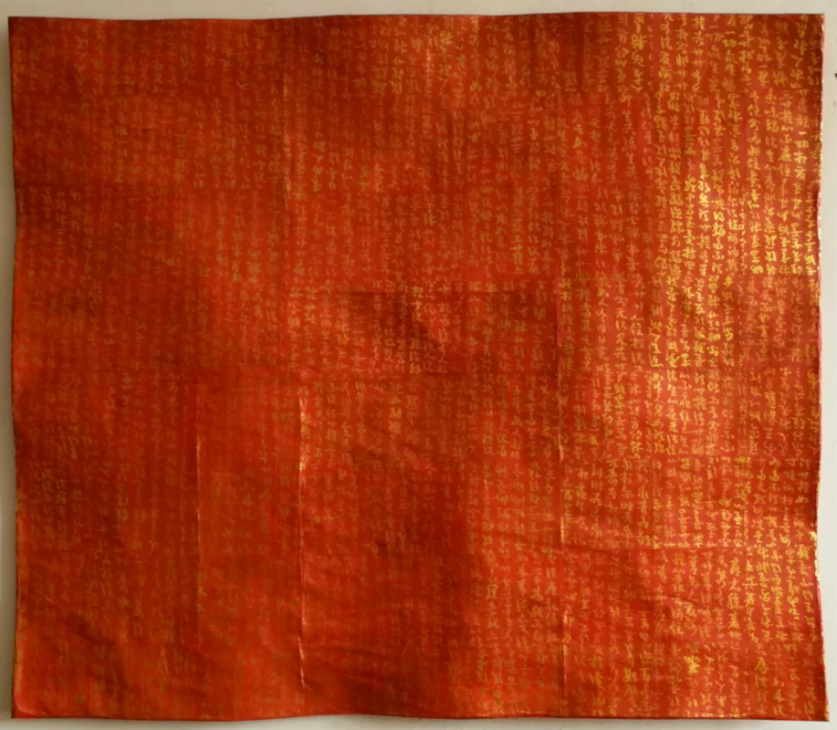 Golden cursive inscriptions from the Diamond Sutra are layered on colored xuan paper and enclosed within steel mesh, creating a mixed-media work that combines writing, materiality, and spatial presence.